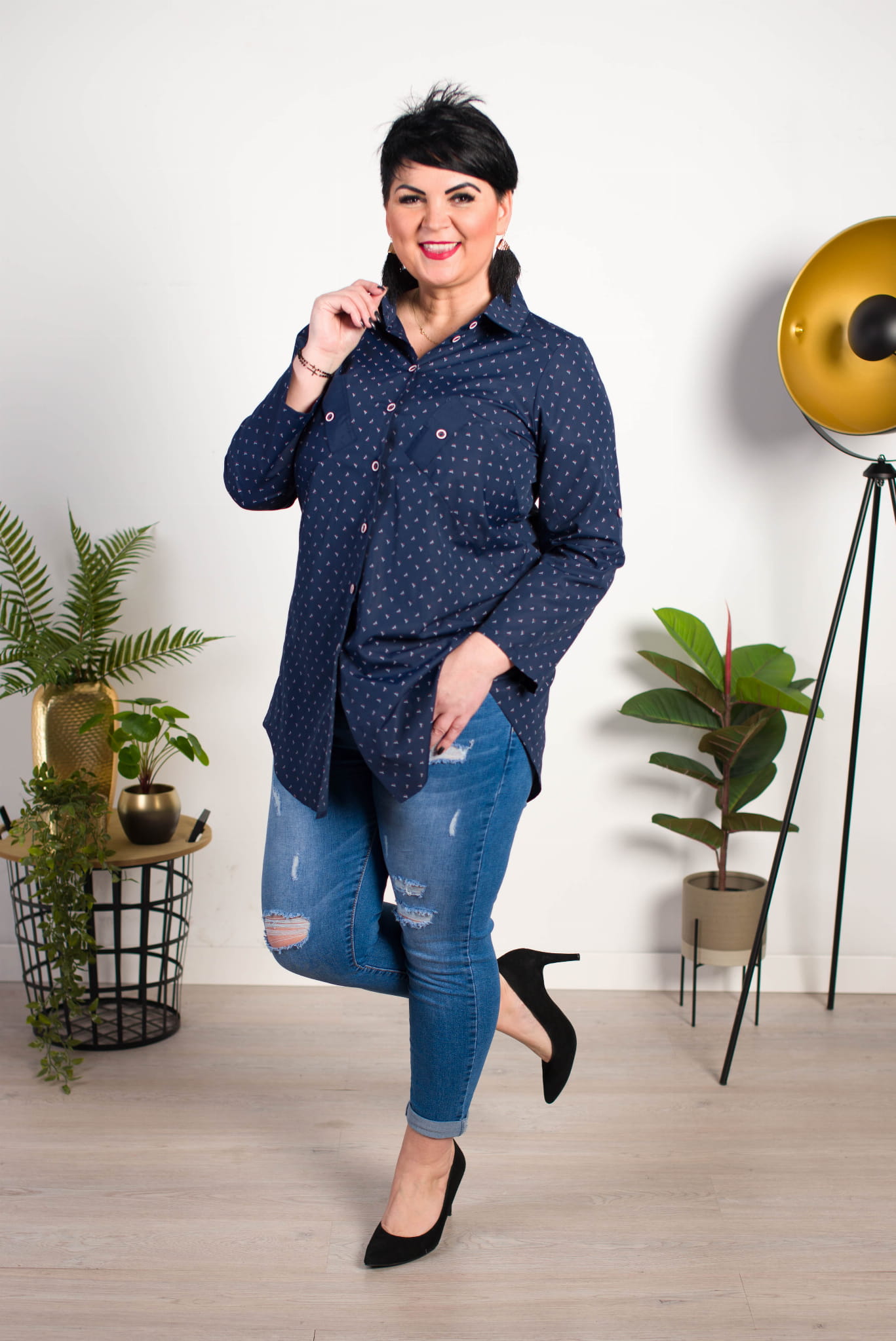 kobieta plus size ubrana w granatową koszulę i jeansy